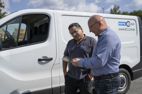 Ein Vetriebsmitarbeiter unterhält sich mit einem Overnight Fahrer über spezielle Kundenanforderungen.