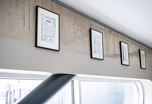 Zertifizierungen nach DIN ISO 9001 hängen an der Wand im Verwaltungsgebäude von euro.COURIER.