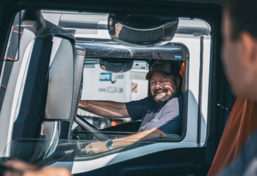 Two people in their respective own truck look at each other through the window