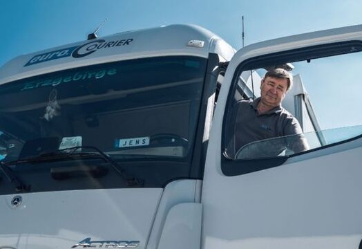 A person looks out of a truck with the door opened
