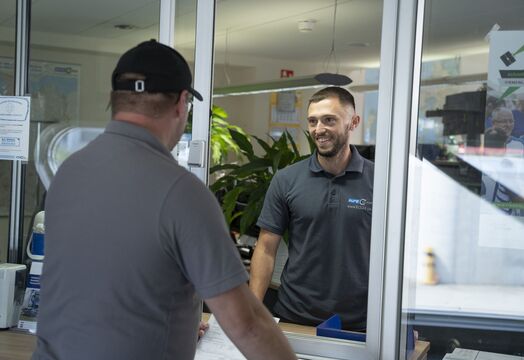 Ein ECL Disponent aus der Abteilung Direktfahrten spricht mit einem Fahrer, beide sind fröhlich.