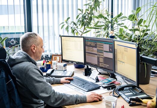 Expressfrachtdisponent sitzt am Schreibtisch.