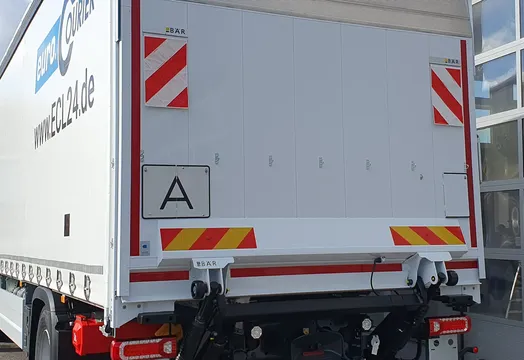LKW mit aufgeklappter Warntafel für Abfalltransporte.