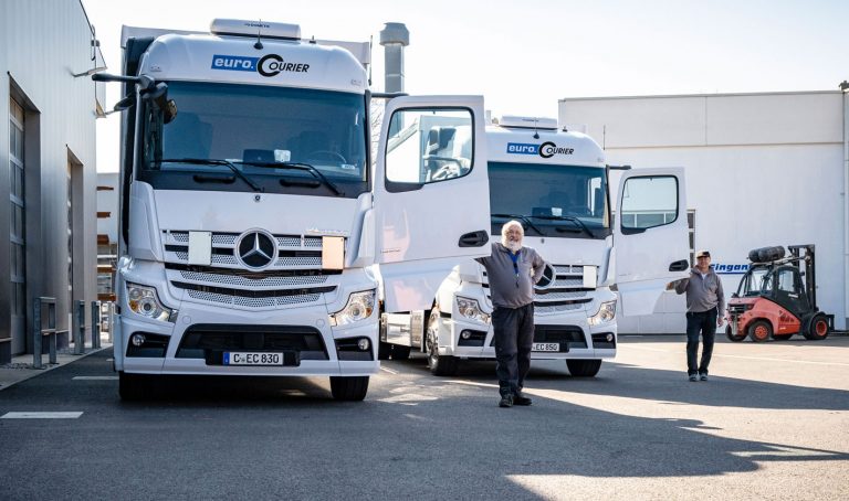 Mitarbeiter stehen vor ihren LKW mit geöffneten Türen